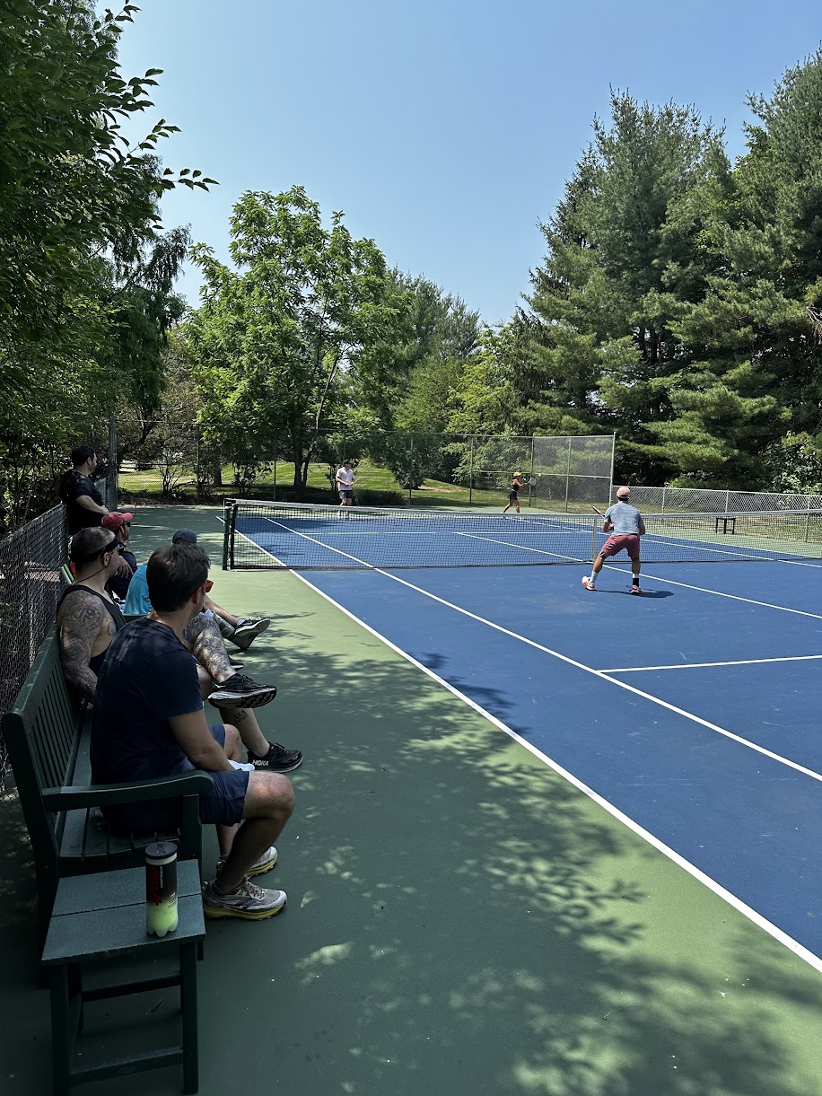 Spectators watching doubles match from seating deck